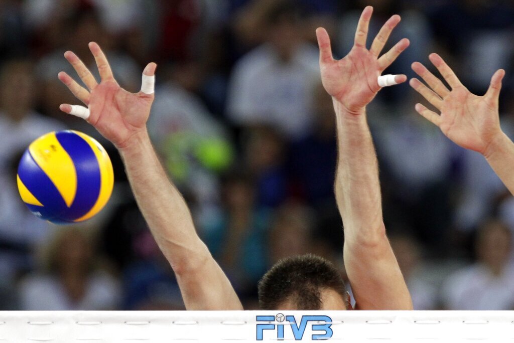 The hands of Serbia's Nikola Grbic, left, and Marko Podrascanin reach out for the ball during their semifinal match against Cuba, at the Men's Volleyball World Championships in Rome, Saturday, Oct. 9, 2010. (AP Photo/Andrew Medichini)