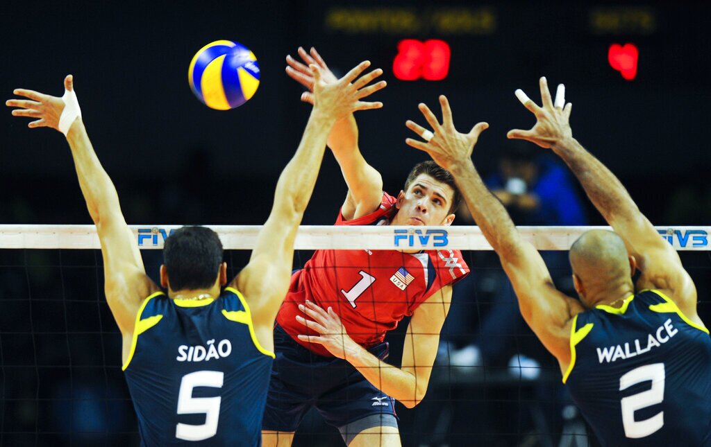 Matthew Anderson of the U.S. spikes the ball against Brazil's Sidnei dos Santos Jr., left, and Wallace Martins during their FIVB Men's Volleyball World League Intercontinental round match in Belo Horizonte, Brazil, Sunday June 12, 2011. (AP Photo/Eugenio Savio)