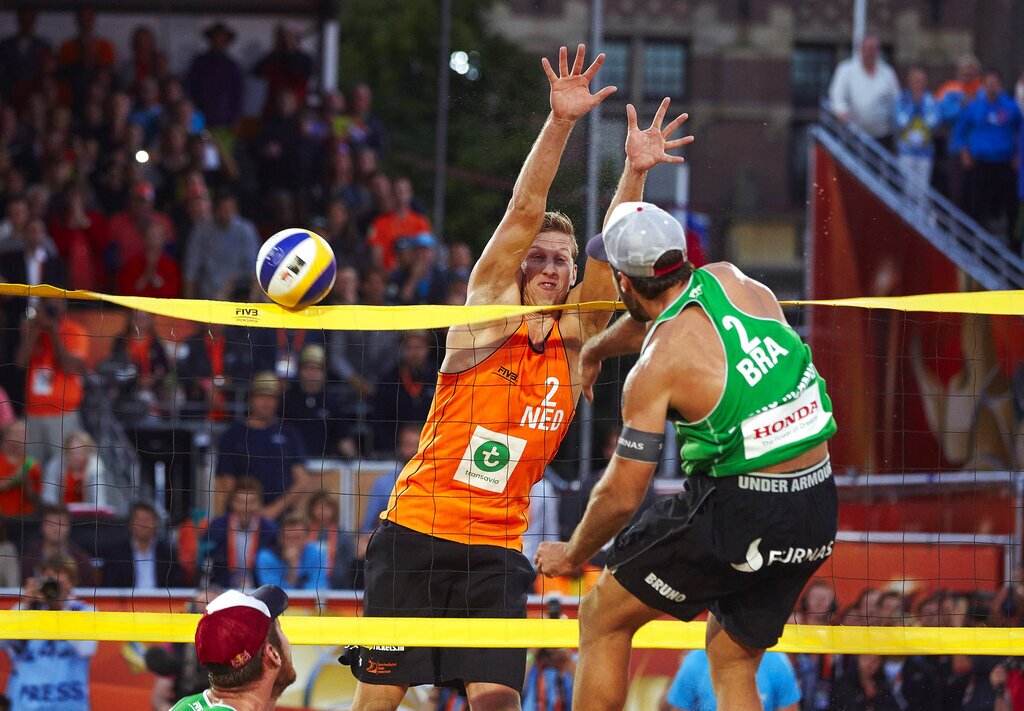 Brazil's Bruno Oscar Schmidt spikes the ball onto the net as Netherlands' Christiaan Varenhorst defends, during the FIVB Beach Volleyball World Championships men's final game in The Hague, Netherlands on Sunday, July 5, 2015. (AP Photo/Phil Nijhuis)