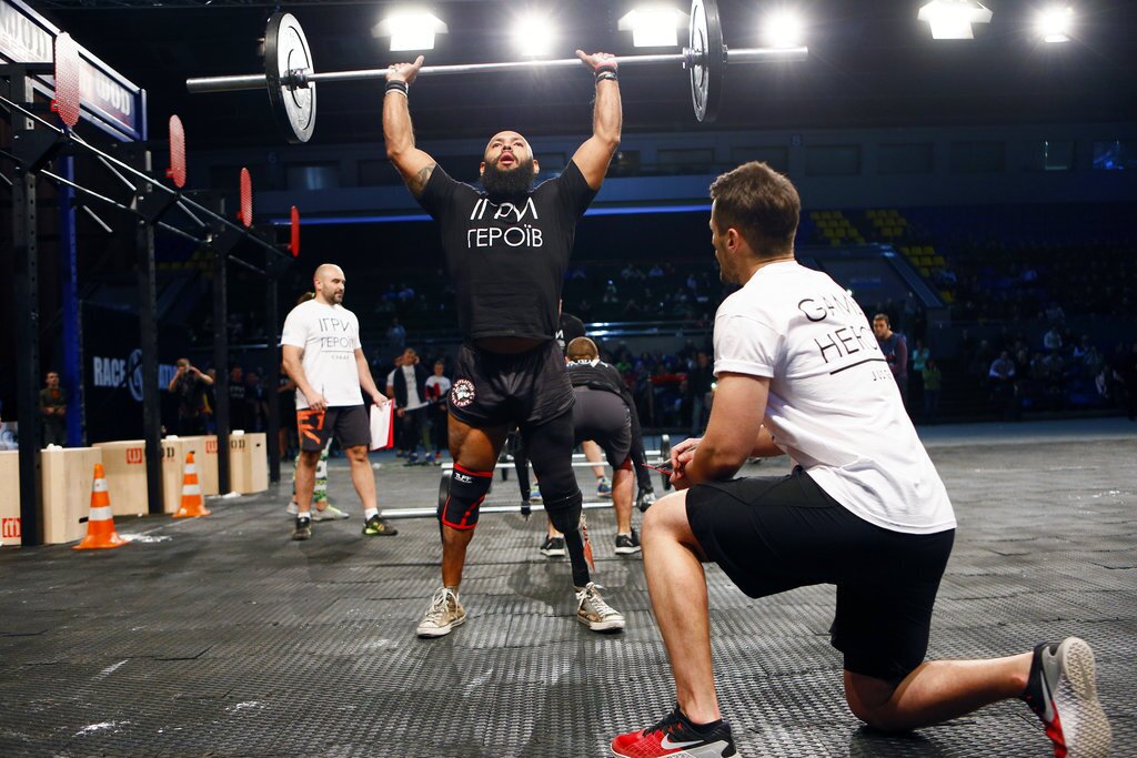 US Staff Sgt. Jose Luis Sanchez, a retired Marine who lost a leg in Afghanistan, lifts weights during the Games of Heroes competition for disabled servicemen at the Sport Arena in Kiev, Ukraine, Tuesday Dec.19, 2017. About 50 wounded soldiers and veterans participated in Ukraine's Game of Heroes, which included weightlifting, rope climbing and rowing machines. (AP Photo/Efrem Lukatsky)