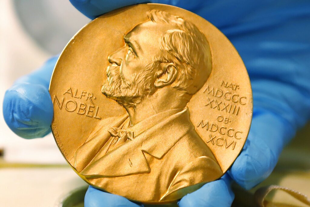 FILE- A national library employee shows a gold Nobel Prize medal in Bogota, Colombia Friday, April 17, 2015. (AP Photo/Fernando Vergara, file)