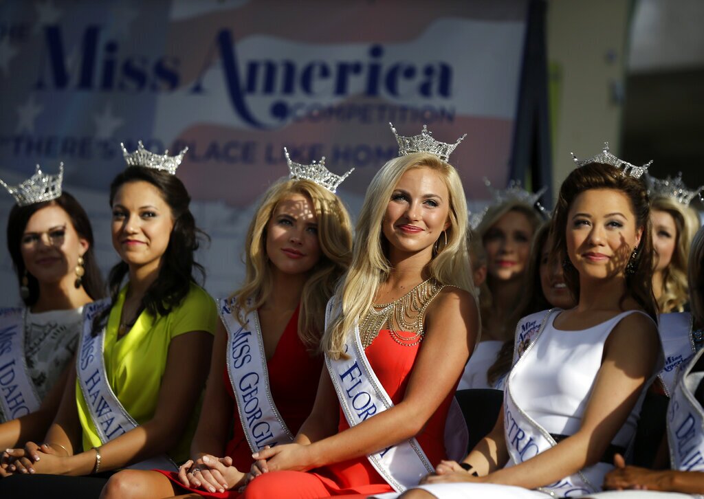 Miss America Pageant contestants, from left, Miss Idaho Sierra Sandison, Miss Hawaii Stephanie Steuri, Miss Georgia Maggie Bridges, Miss Florida Victoria Cowan, and Miss District of Columbia Teresa Davis watch arrival ceremonies Wednesday, Sept. 3, 2014, in Atlantic City, N.J. Miss America contestants from all 50 states, the District of Columbia, Puerto Rico and the U.S. Virgin Islands will appear Wednesday afternoon at the traditional welcoming ceremony across from Boardwalk Hall. (AP Photo/Mel Evans)